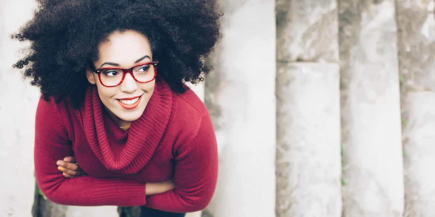 Portrait of smiling young woman standing on stairs