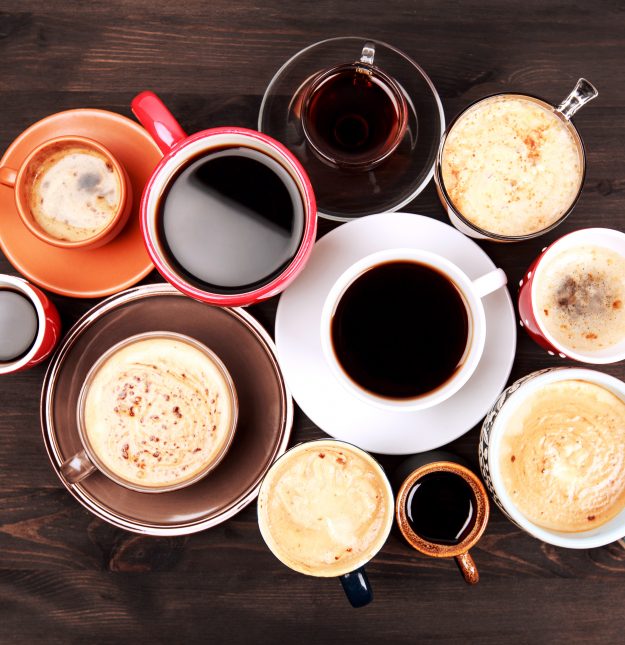 Many cups of coffee on wooden table